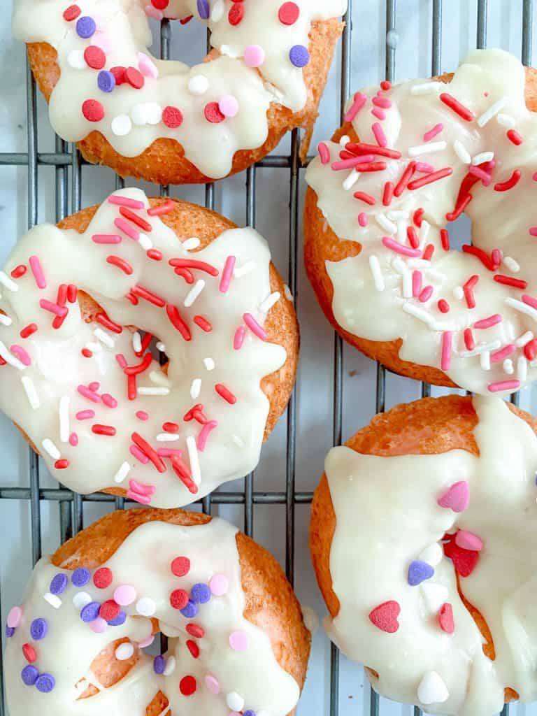 Strawberry cake donuts with white chocolate glaze and sprinkles