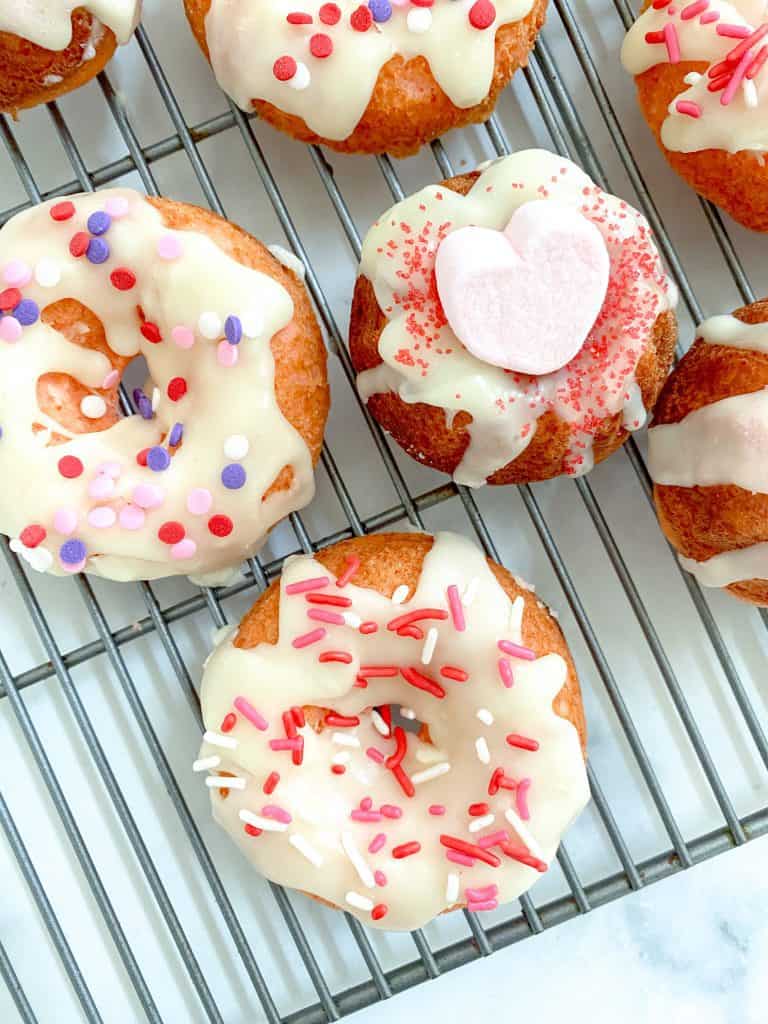 Strawberry cake donuts with white chocolate glaze and sprinkles