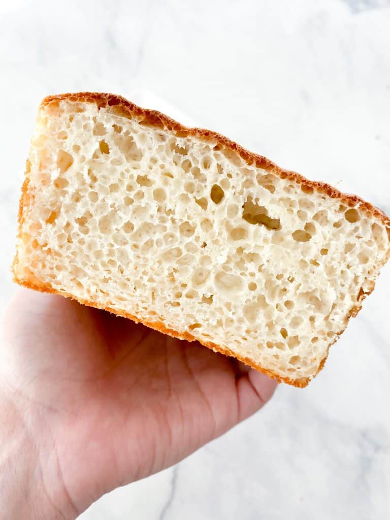 Sliced English muffin loaf held in hand