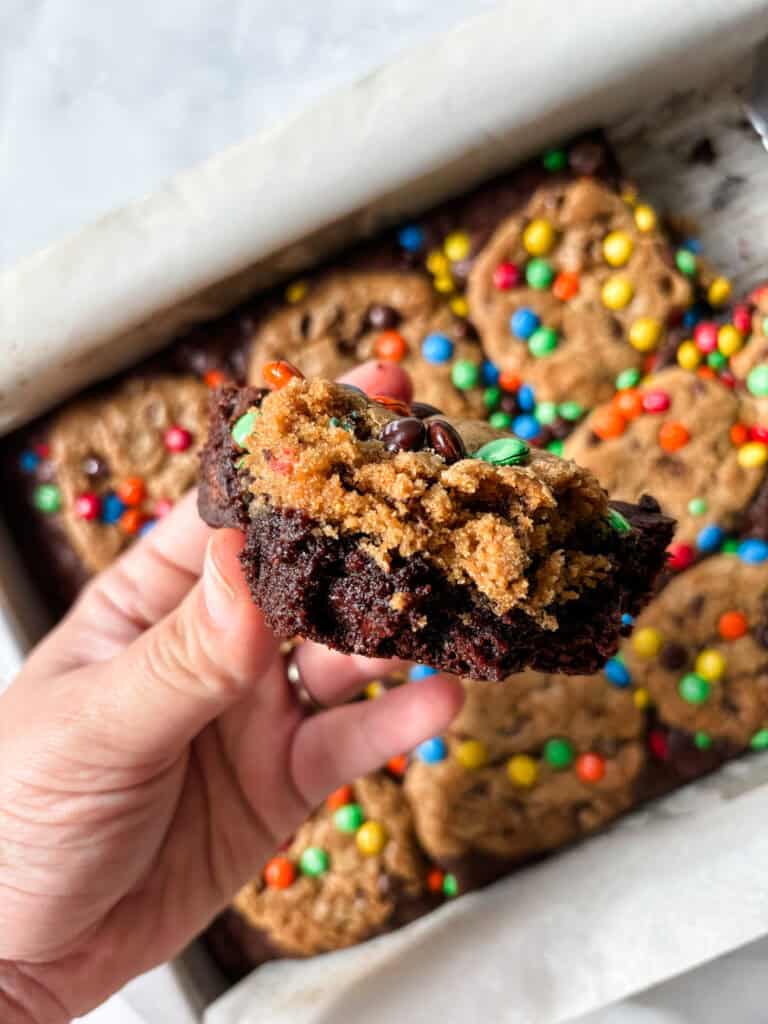 holding a piece of brownie cookie