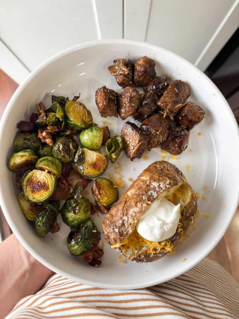 overhead shot of dish with maple Brussels sprouts, meat and a potato
