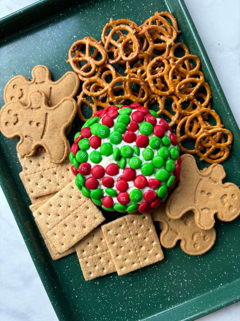 overhead view of a dessert dip with M&M'S, graham crackers, pretzels and gingerbread men.