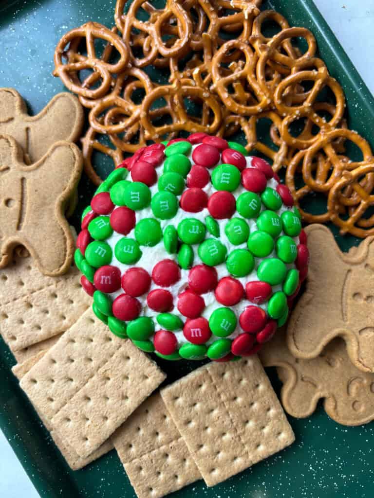 close up view of a dessert dip with M&M'S, graham crackers, pretzels and gingerbread men.